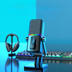 RGB USB microphone on a gaming desk beside a headset and backlit keyboard