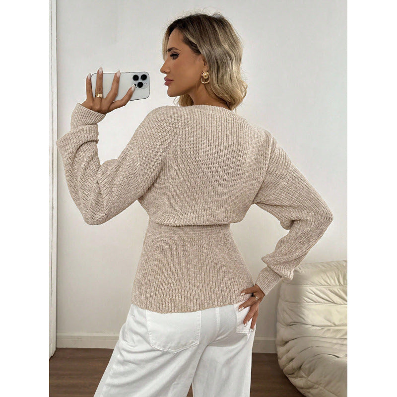 Apricot ribbed knit V neck cardigan with gold buttons worn open over white trousers