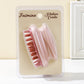Pink silicone scalp shampoo brush on a blister card with soft bristles