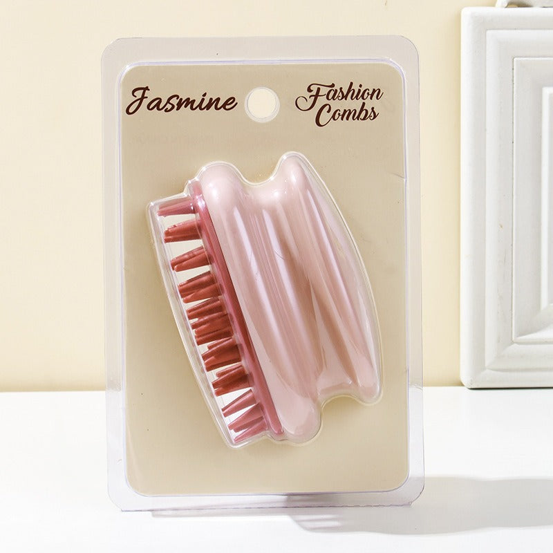 Pink silicone scalp shampoo brush on a blister card with soft bristles