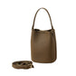 Leather bucket bag carried at the hip on its shoulder strap in daily use