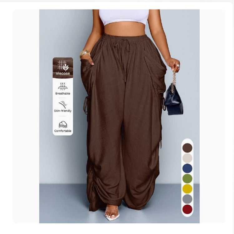High waist wide leg linen look viscose drawstring trousers, front view on a model with hands in the deep pockets