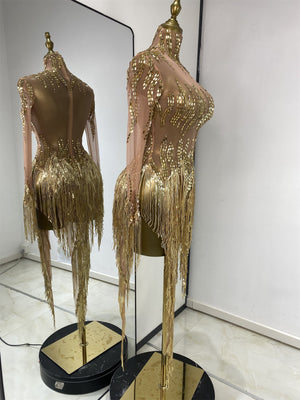 Gold sequin performance dress with rhinestone accents on stage