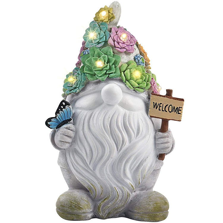 Resin garden gnome with succulent flower hat, butterfly and WELCOME sign on a white background