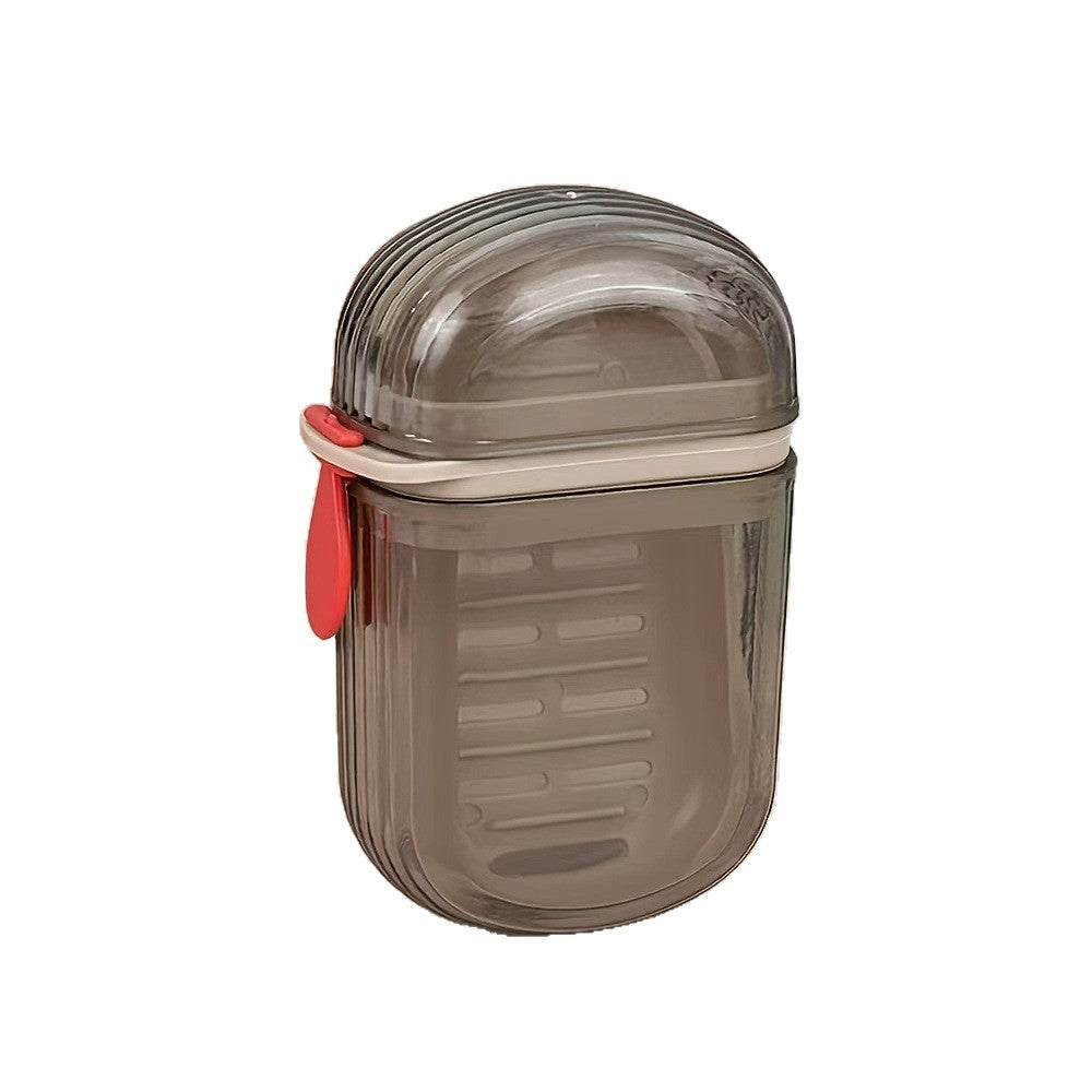 Closed translucent smoke gray soap case with a red silicone tab and beige band on a white background