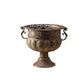 Antique style iron urn on a round foot with scroll handles and gold highlights on a white background