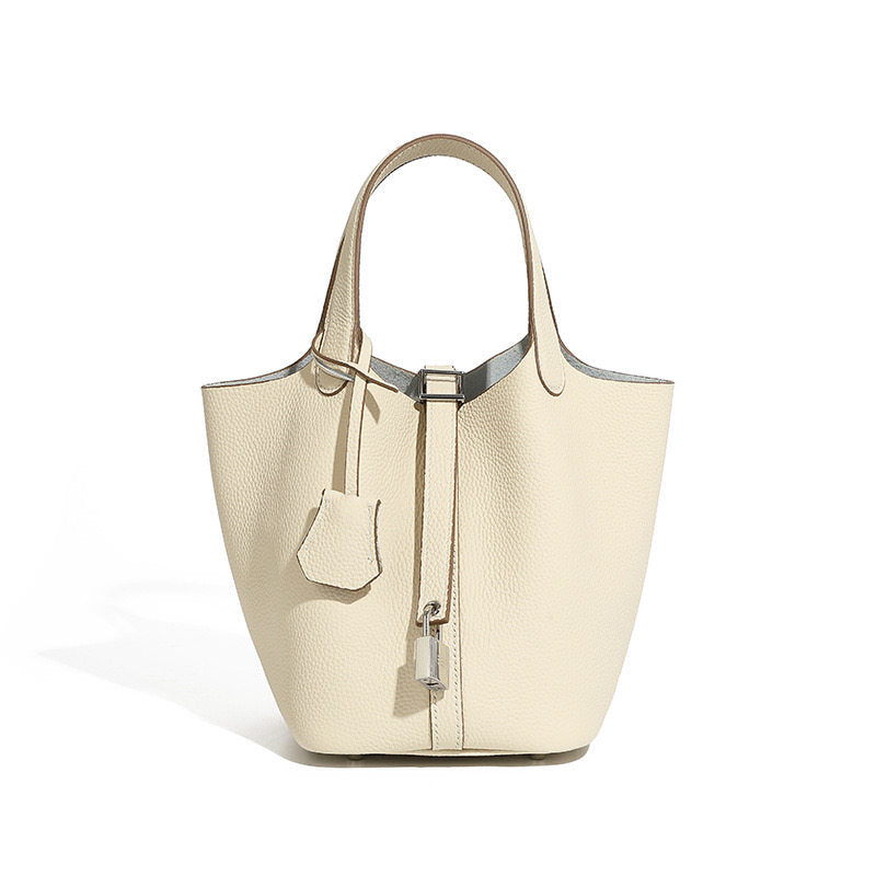 Leather bucket tote bag opening drawn closed under the metal clasp