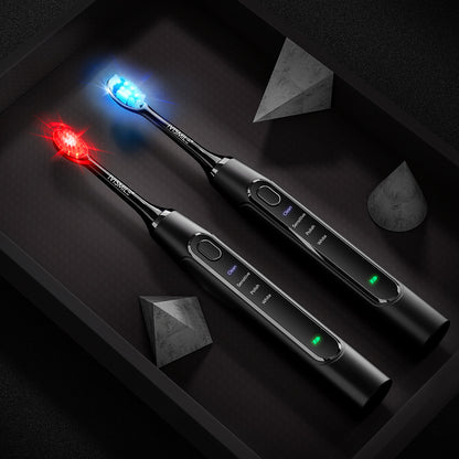 Two black IVISMILE electric toothbrushes lit with a blue and a red LED light in the brush head on a dark tray