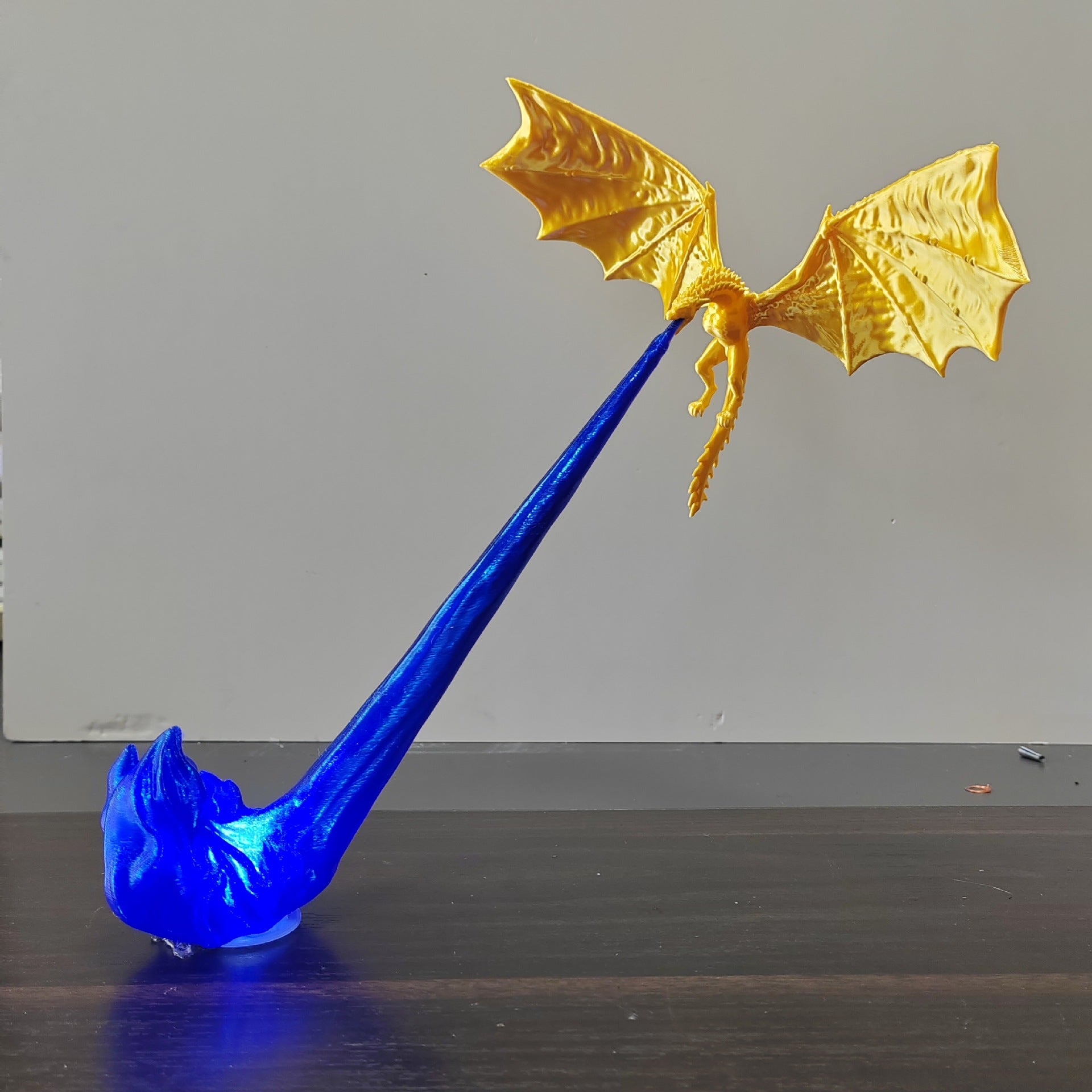 Two lit dragon ornaments glowing in blue and orange on a dark tabletop