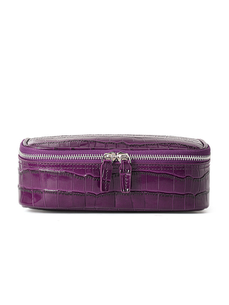 Purple crocodile pattern leather cosmetic bag, front view with double zipper on a white background