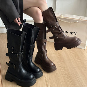 Brown and black platform mid calf buckle boots displayed together on a wood floor