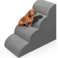 Dachshund sitting on the upper tier of gray foam pet stairs on a plain white background