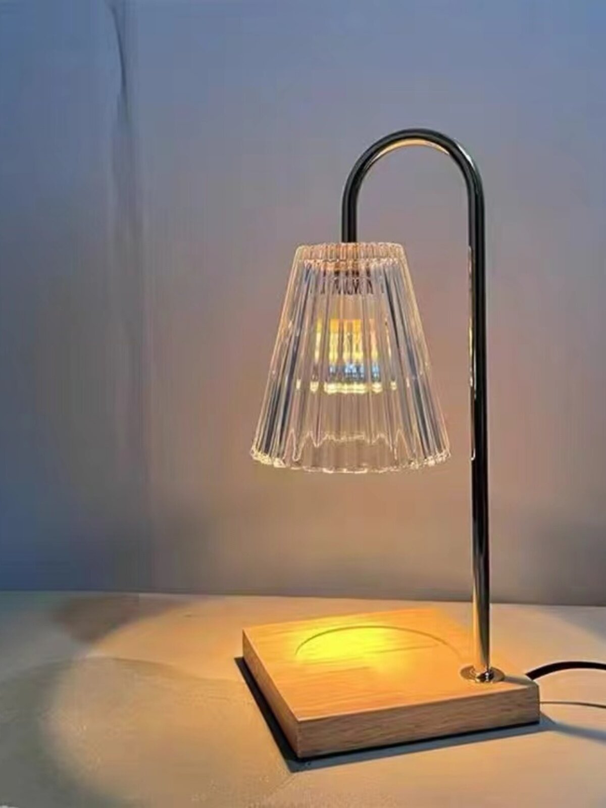 Warm amber glow from the candle warmer lamp on a shelf