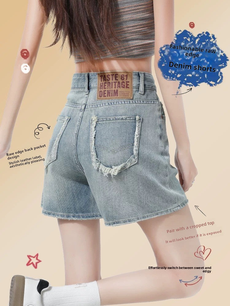Back view of high-waisted raw-edge denim shorts in faded blue on a walking model