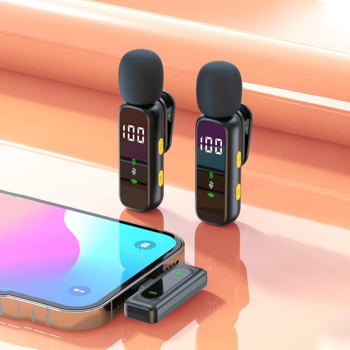 Two lavalier mics beside a phone with the receiver plugged in for recording
