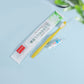 Disposable toothbrush and toothpaste travel set beside its clear sealed packaging