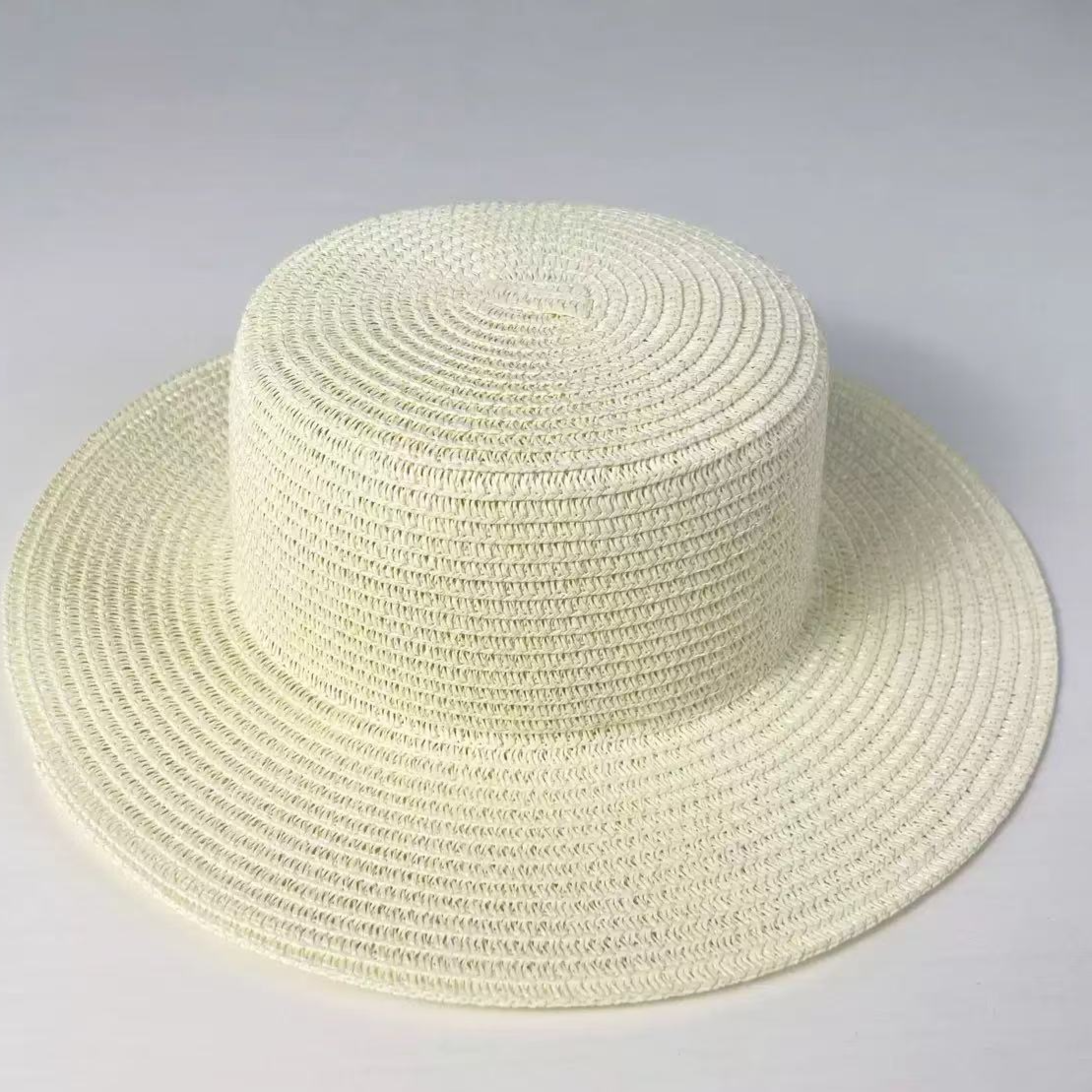 Black woven paper straw sun hat with a flat top crown and a wide flat brim