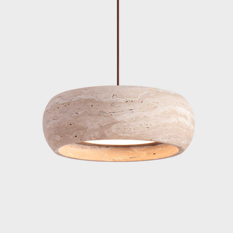 Travertine stone LED pendant light glowing warm over a nightstand in a minimalist bedroom scene