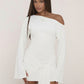 Woman in a white one shoulder bodycon mini dress with wide bell sleeves and a knotted drape at the hip, front view