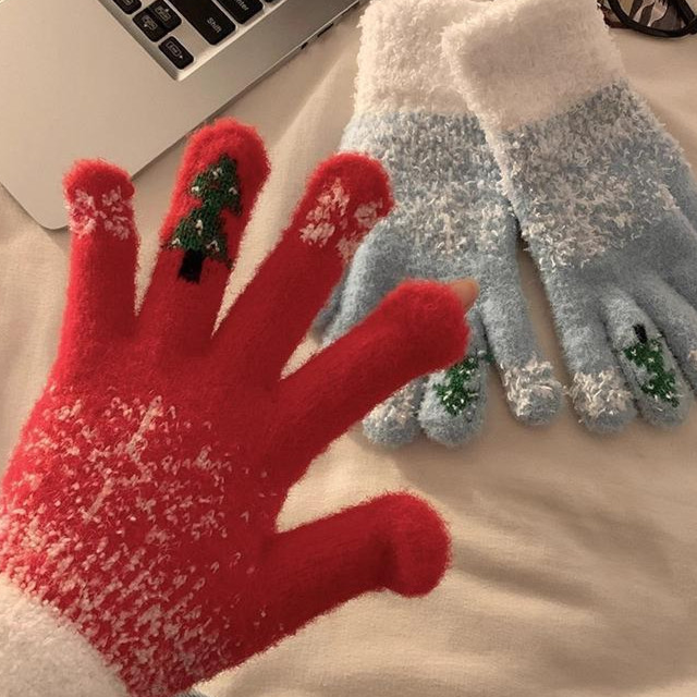 Red fuzzy knit touchscreen gloves with white snowflake pattern and a green tree design