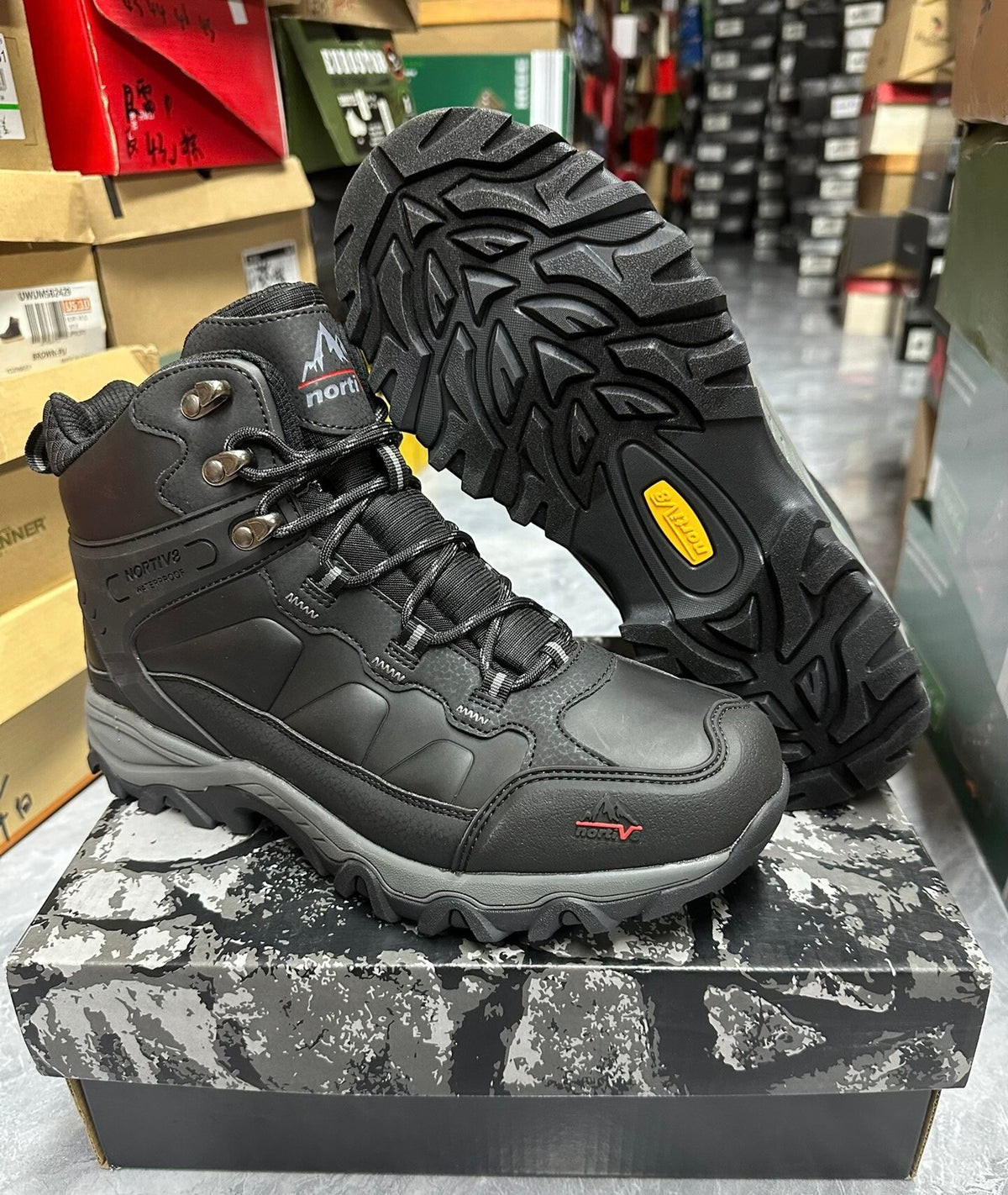 Men's mid-top hiking boots worn on a foot outdoors