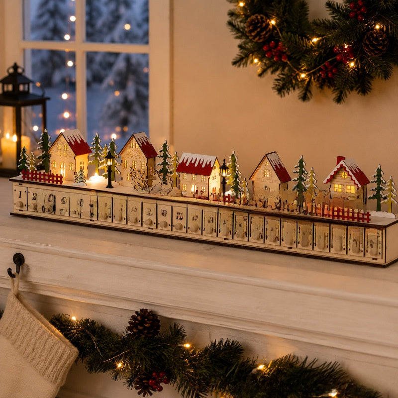 Red roofed wooden advent calendar village lit on a white mantel with garland