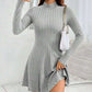 Light gray ribbed knit mock neck long sleeve fit and flare mini dress worn with a white chain shoulder bag