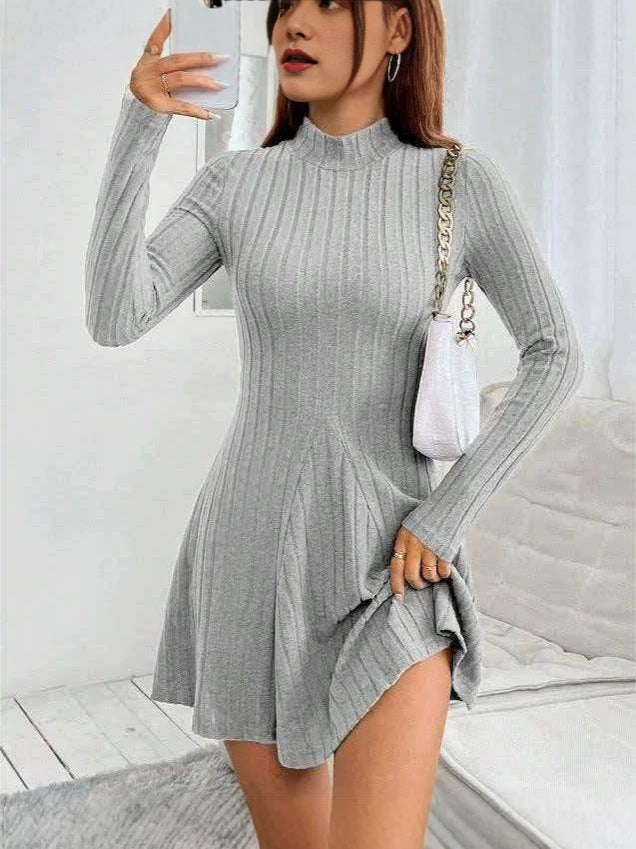 Light gray ribbed knit mock neck long sleeve fit and flare mini dress worn with a white chain shoulder bag