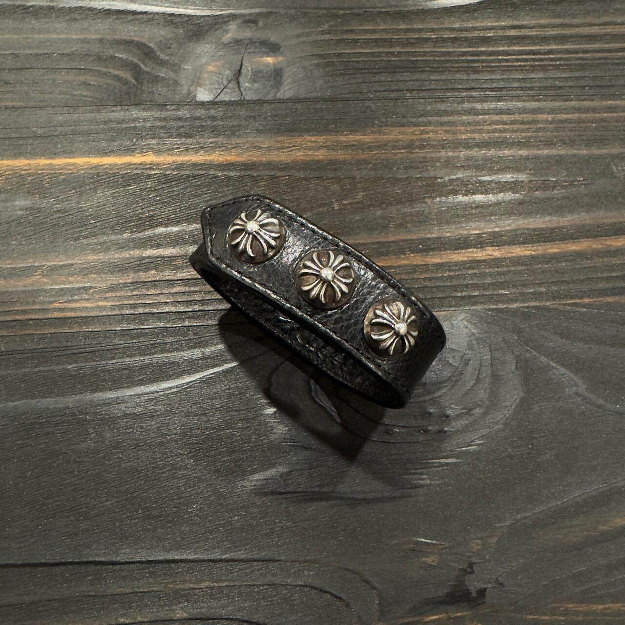 Close up showing the scale of the black leather concho cuff on the wrist
