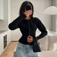 Black rib knit cardigan buttoned from the round neck to the hem over light jeans