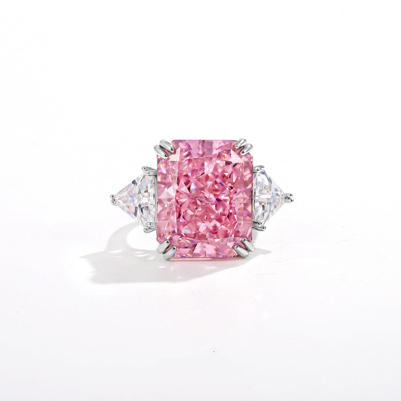 Pink radiant cut simulated diamond between two clear trillion side stones, plain white background