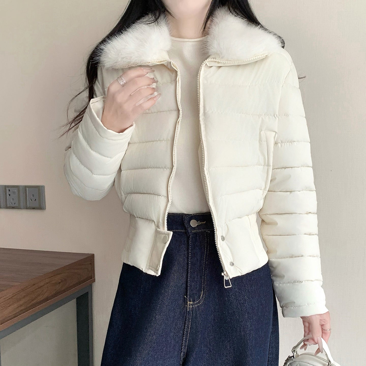 Close view of the synthetic faux fur collar turned down over the front zip