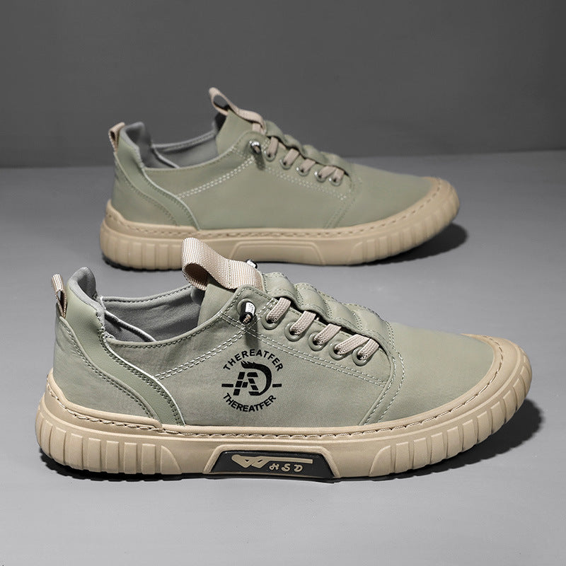 Pair of green lace up canvas sneakers with a beige ribbed sole on a gray backdrop, one shoe seen from above