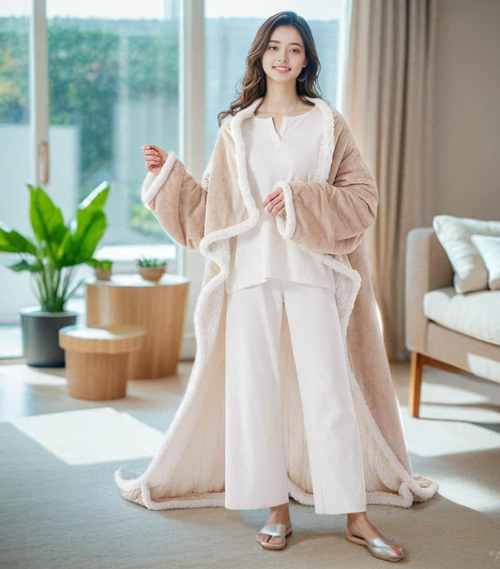 Smiling woman wearing the beige wearable blanket with sleeves and foot pockets in a bright living room