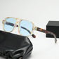 Square double bridge sunglasses with a clear yellow frame and blue lenses beside a box