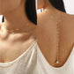 Gold pearl drop chain shown as a front necklace and a back drape