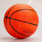 Orange rubber basketball tilted toward the camera, showing crossing black channels and a pebbled cover