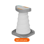 Light mist gray and white push-up support stand with a ribbed elastic column, curved top pad and gray base plate