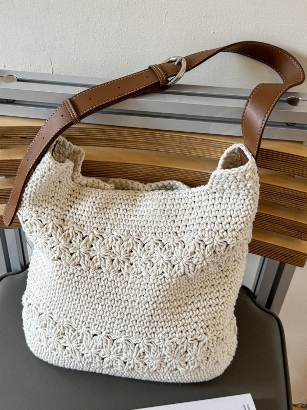 Off-white cotton woven bag showing brown leather buckle strap