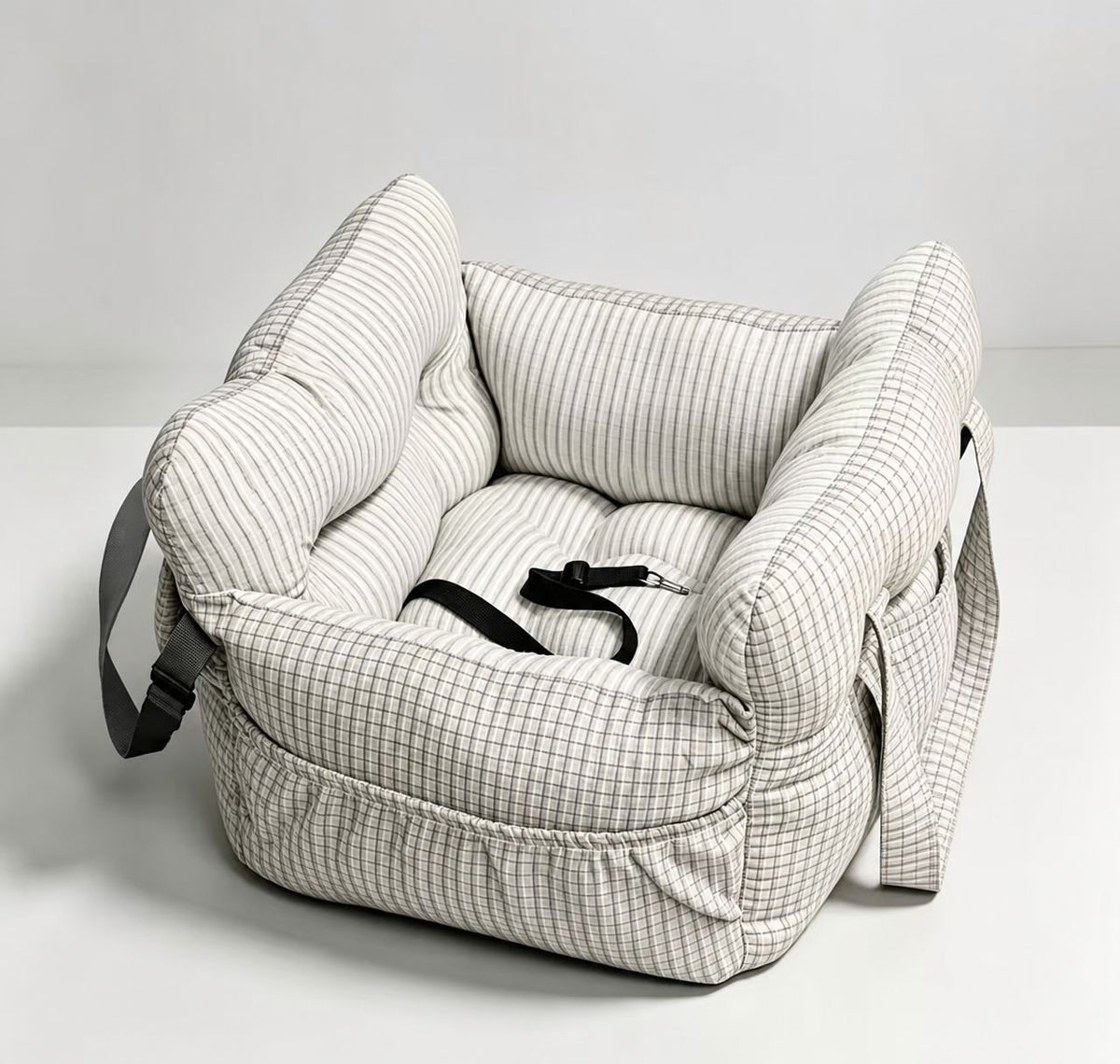Padded car seat pet bed with raised bolster walls, carry handles and an inner clip the larger size shown on a bench seat