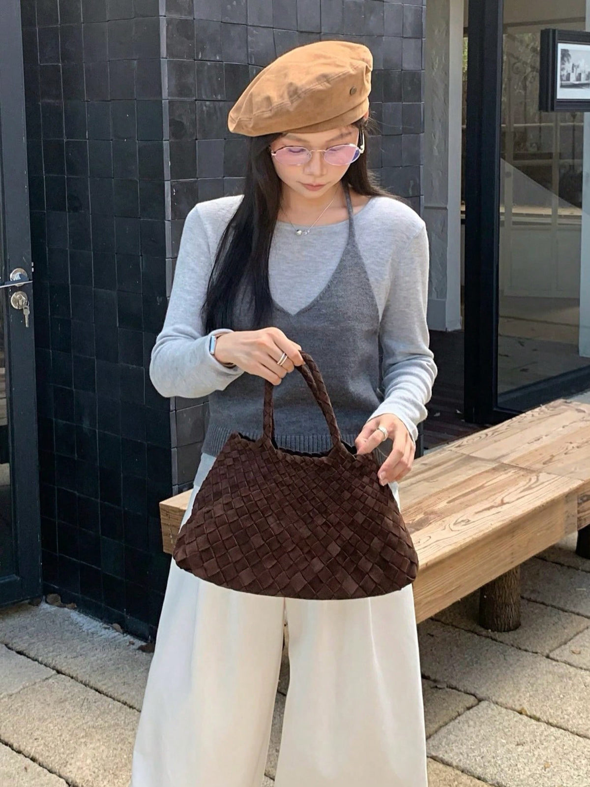 Woman in a grey vest and beret holding the Frosted brown woven handbag, Frosted brown variant