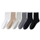 Flat lay row of all six sock colours, white, khaki, light grey, dark grey, navy and black
