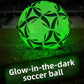 Glow in the dark soccer ball shining bright green on a night pitch with the caption Glow-in-the-dark soccer ball