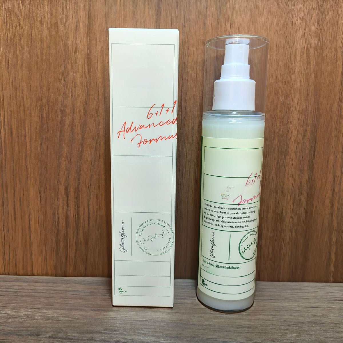AXIS-Y Dark Spot Correcting Glow Toner carton beside its clear pump bottle on a wooden shelf