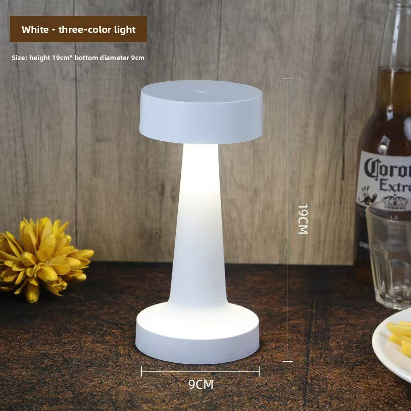White pillar table lamp with three color light on a table