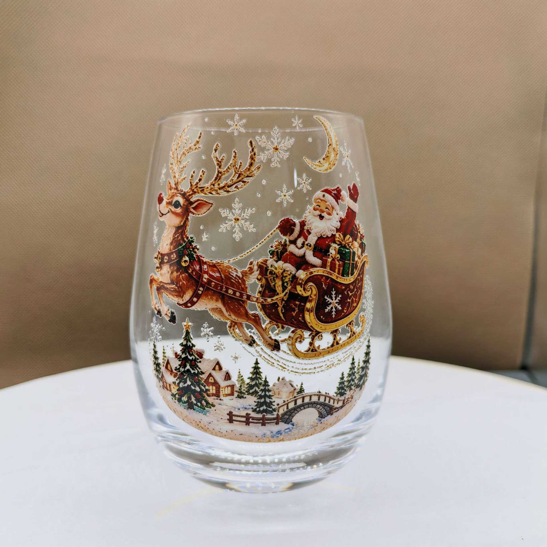 Clear borosilicate Christmas glass cup with a raised painted flat sleigh and reindeer holiday motif