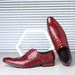 Pair of wine red crocodile embossed derby shoes beside a white hexagon stand, one shoe showing the black interior