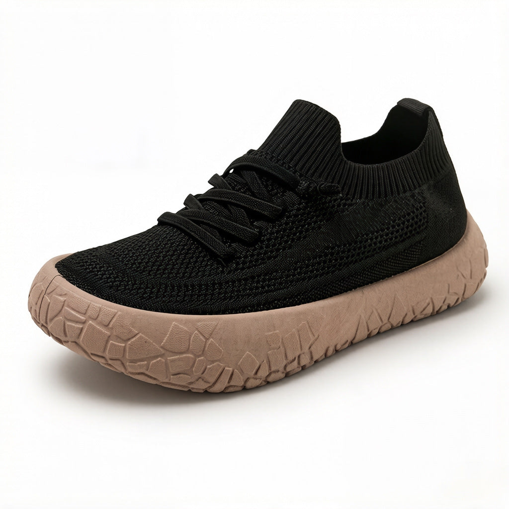 Black knit mesh slip-on sneaker with flat criss-cross laces and a thick tan crackle-pattern sole on white