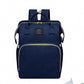 Blue diaper backpack in a dark navy tone, front view with two top handles, a woven label and a front zip pocket