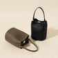 Genuine leather bucket bag side profile showing the shoulder strap and tall body
